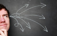man thinking critically against blackboard. chalk arrows sprouting out of head as idea